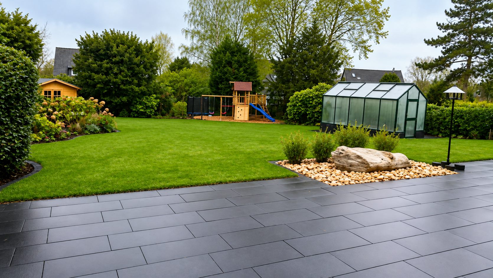 Garten mit Rasenfläche, Pflanzen, Gewächshaus und Steinfläche